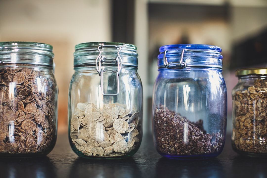 four glass jars filled with different types of food