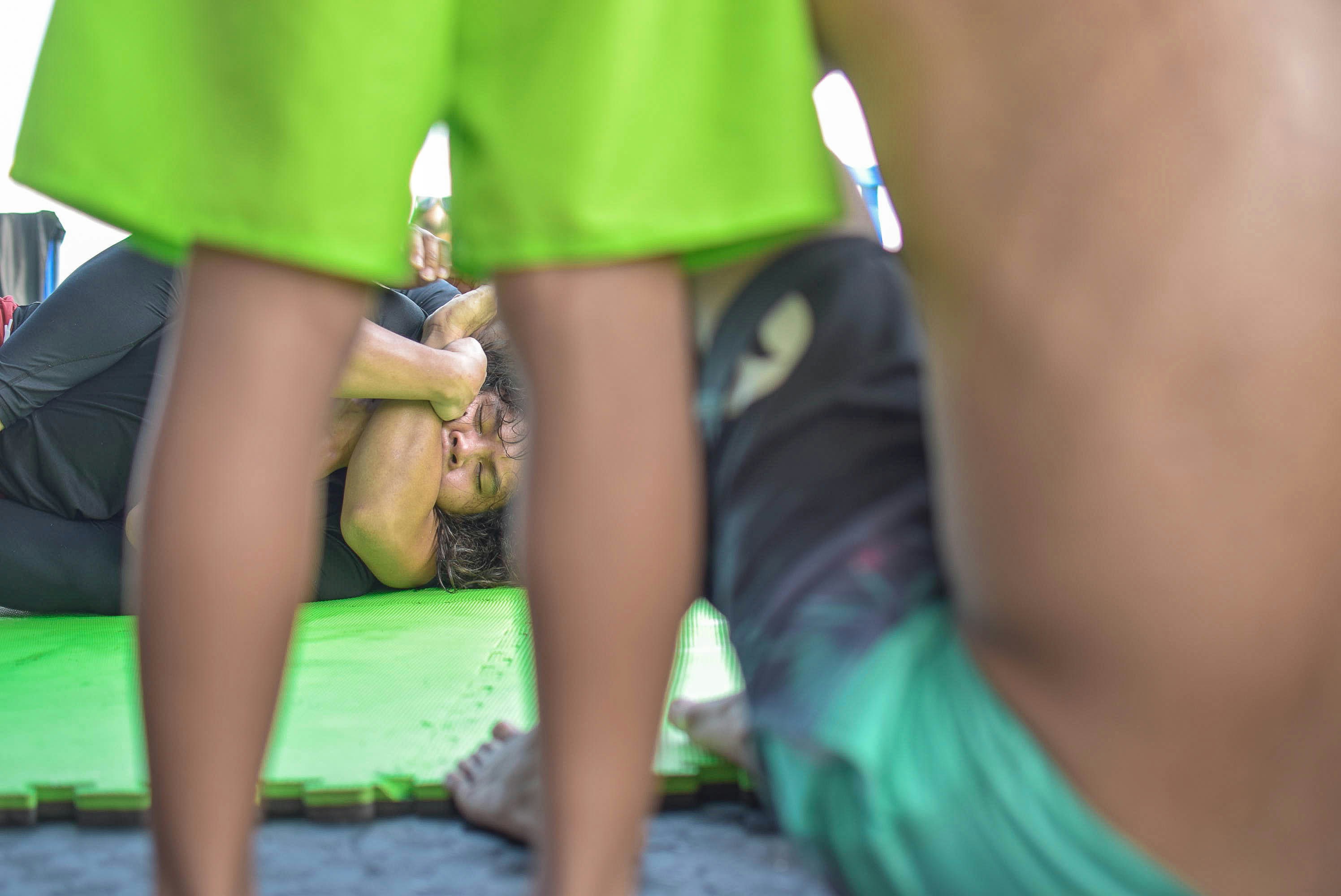 person in green shorts lying on green textile